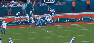 A Football Game Is Being Played On A Field That Has The Word Dolphins Written On It GIF