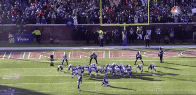 A Football Game Is Being Played On A Field With A Banner That Says Verizon In The Background GIF