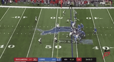 A Football Game Is Being Played On A Field With A Crowd Watching . GIF