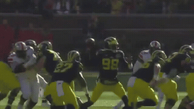 A Football Game Is Being Played On A Field With A Crowd Watching GIF