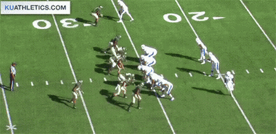 A Football Game Is Being Played On A Field With A Kuathletics.com Logo In The Corner GIF
