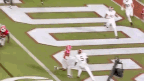 A Football Game Is Being Played On A Field With A Large Number On The Field . GIF