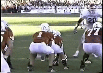 A Football Game Is Being Played On A Field With A Player Wearing Number 77 GIF
