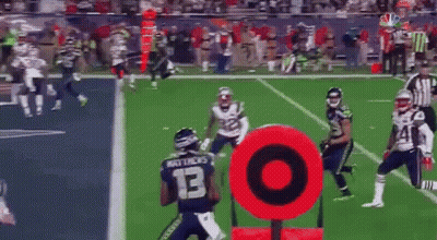 A Football Game Is Being Played On A Field With A Red Target In The Foreground GIF