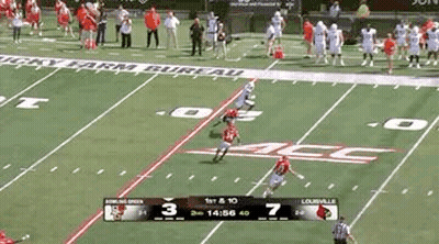 A Football Game Is Being Played On A Field With A Scoreboard Showing The Score . GIF