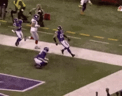 A Football Game Is Being Played On A Field With Players Running Down The Field . GIF