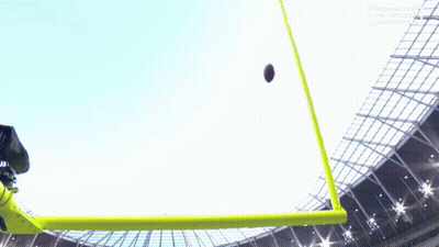 A Football Is Being Kicked Into The Air By A Referee GIF