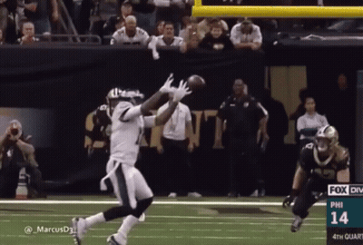 A Football Player Catches A Ball During A Game With The Number 14 On The Bottom Right GIF