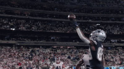 A Football Player Catches A Ball In A Stadium That Has The Word Cowboys On It GIF