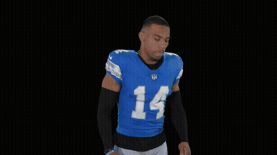A Football Player Flexes His Muscles In A St Brown 14 Jersey GIF