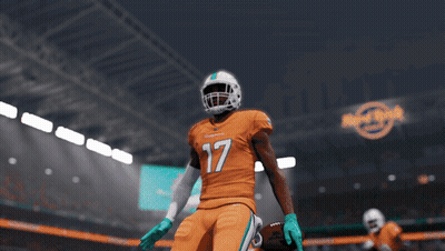 A Football Player For The Miami Dolphins Is Standing In A Stadium GIF