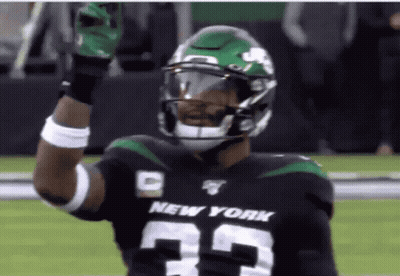 A Football Player For The New York Jets Holds Up His Gloves GIF