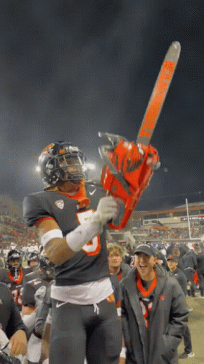 A Football Player Holding A Chainsaw That Says Timberwolf On It GIF