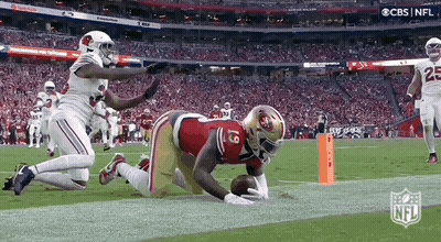 A Football Player In A 49Ers Uniform Is Kneeling On The Field . GIF