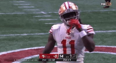 A Football Player In A 49Ers Uniform Is Standing On The Field . GIF