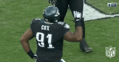 A Football Player In A Black Uniform Is Running On The Field . GIF