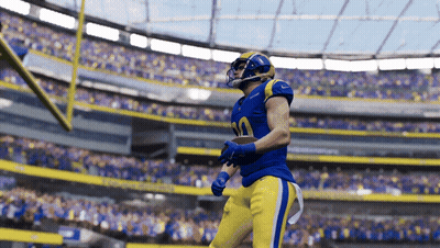A Football Player In A Blue And Yellow Uniform With The Number 30 On His Jersey GIF