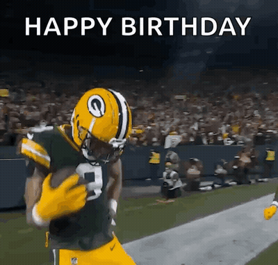 A Football Player In A Green Bay Packers Uniform Is Running With The Ball . GIF