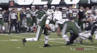 A Football Player In A Jets Uniform Is Running On The Field . GIF