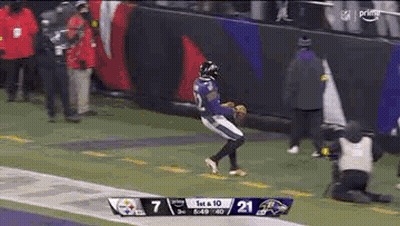 A Football Player In A Purple Uniform Is Running On A Field . GIF