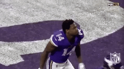 A Football Player In A Purple Uniform Is Running On A Field . GIF
