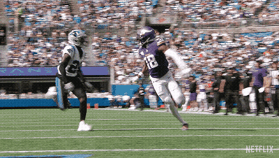 A Football Player In A Purple Uniform With The Number 12 On It GIF