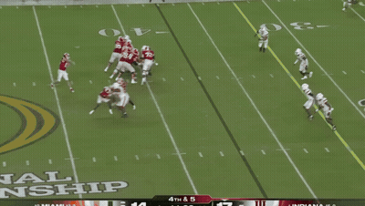 A Football Player In A Red Indiana Jersey Is Being Tackled By Another Player GIF
