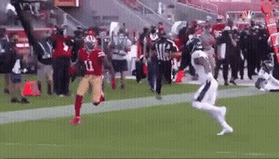 A Football Player In A Red Jersey Is Running On A Field . GIF