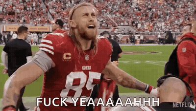 A Football Player In A Red Jersey Is Standing On A Field With His Arms Outstretched . GIF