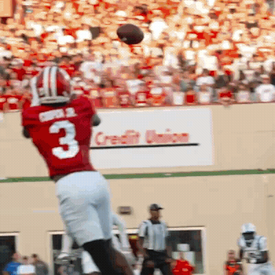 A Football Player In A Red Jersey With The Number 3 Catching A Ball GIF