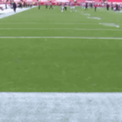 A Football Player In A Red Uniform Is Running On The Field GIF