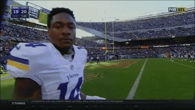 A Football Player In A Vikings Uniform Stands In Front Of A Crowd GIF