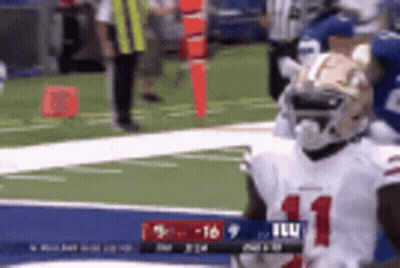 A Football Player In A White Jersey With The Number 11 On It Is Standing On A Field . GIF