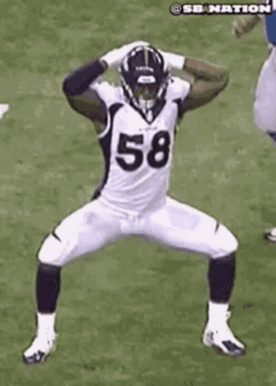 A Football Player In A White Uniform With The Number 58 On It Is Dancing On A Field . GIF