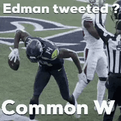 A Football Player Is Being Tackled By A Referee On A Field While Holding A Football . GIF