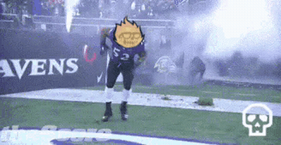A Football Player Is Dancing On The Field While A Fireworks Display Is Going On In The Background . GIF