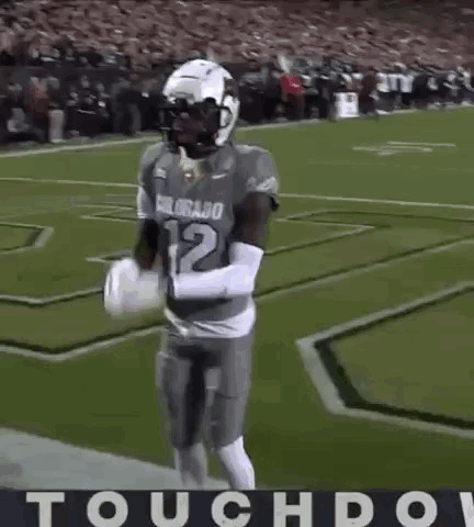 A Football Player Is Dancing On The Field With The Word Touchdown In The Corner . GIF