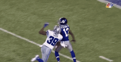 A Football Player Is Flying Through The Air While Catching A Ball . GIF