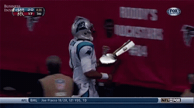 A Football Player Is Holding A Trophy In Front Of A Banner That Says Business GIF