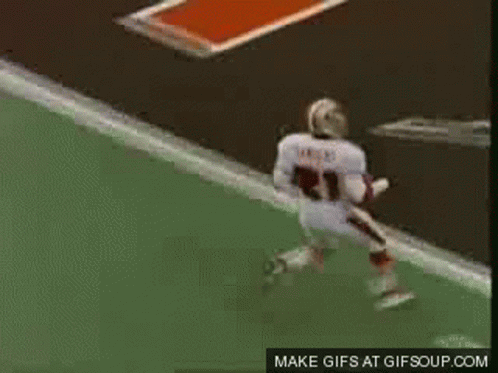 A Football Player Is Jumping In The Air While A Referee Watches . GIF