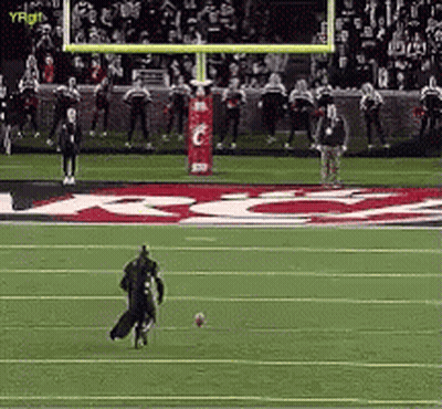 A Football Player Is Kicking A Ball On A Field With A Sign That Says ' Gatorade ' In The Background GIF