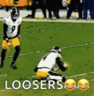 A Football Player Is Kneeling Down On The Field While Another Player Is Running . GIF