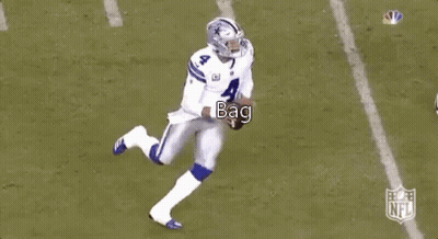 A Football Player Is Kneeling Down On The Field While Another Player Runs Behind Him . GIF
