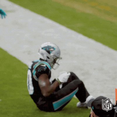A Football Player Is Kneeling On The Field During A Game GIF
