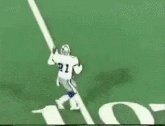 A Football Player Is Running On A Field In Front Of A Huge Nfl Logo GIF