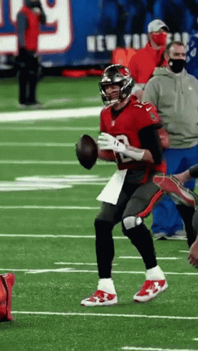 A Football Player Is Running On A Field With A Ball In His Hand . GIF