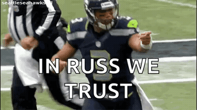 A Football Player Is Running On A Field With The Words `` In Russ We Trust '' Written On The Screen . GIF