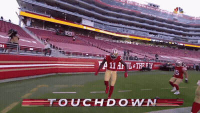 A Football Player Is Running On A Field With The Words Touchdown Written On It GIF