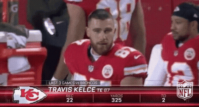 A Football Player Is Sitting In The Stands Watching A Game Between The Kansas City Chiefs And The Broncos GIF