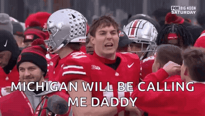 A Football Player Is Standing In Front Of A Crowd Of People And Talking To Them . GIF